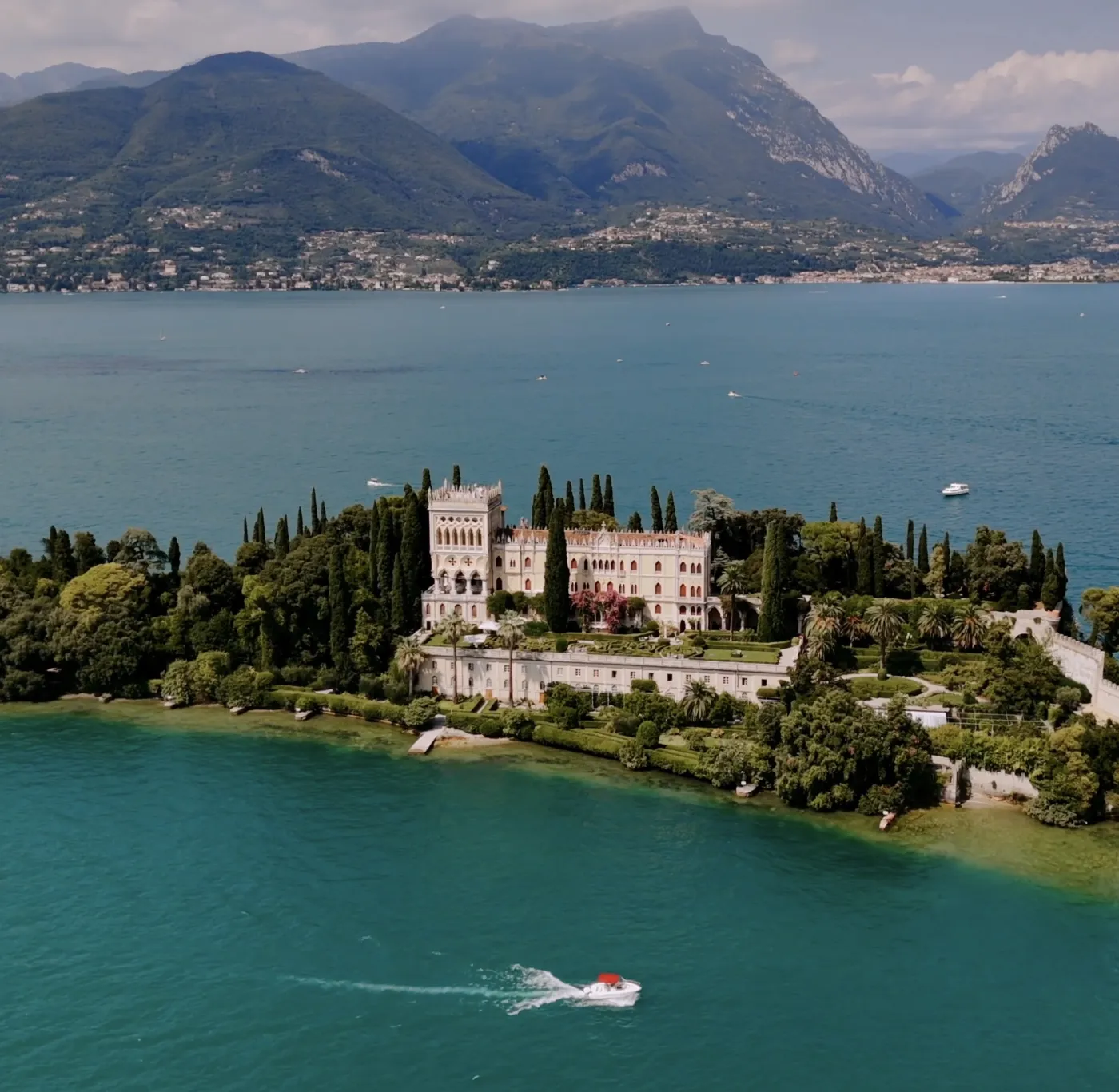 Aerial view of a lakeside villa under mountains, from a PS Visuals film